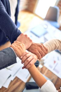 group of business workers standing with hands together doing symbol at the office stockpack unsplash scaled 1